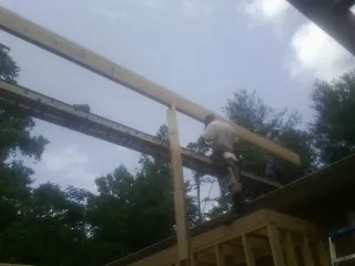 Carpenter setting a ridge beam over a new addition frame — Ice Dam Removal by Roofing Brothers in Donegal
