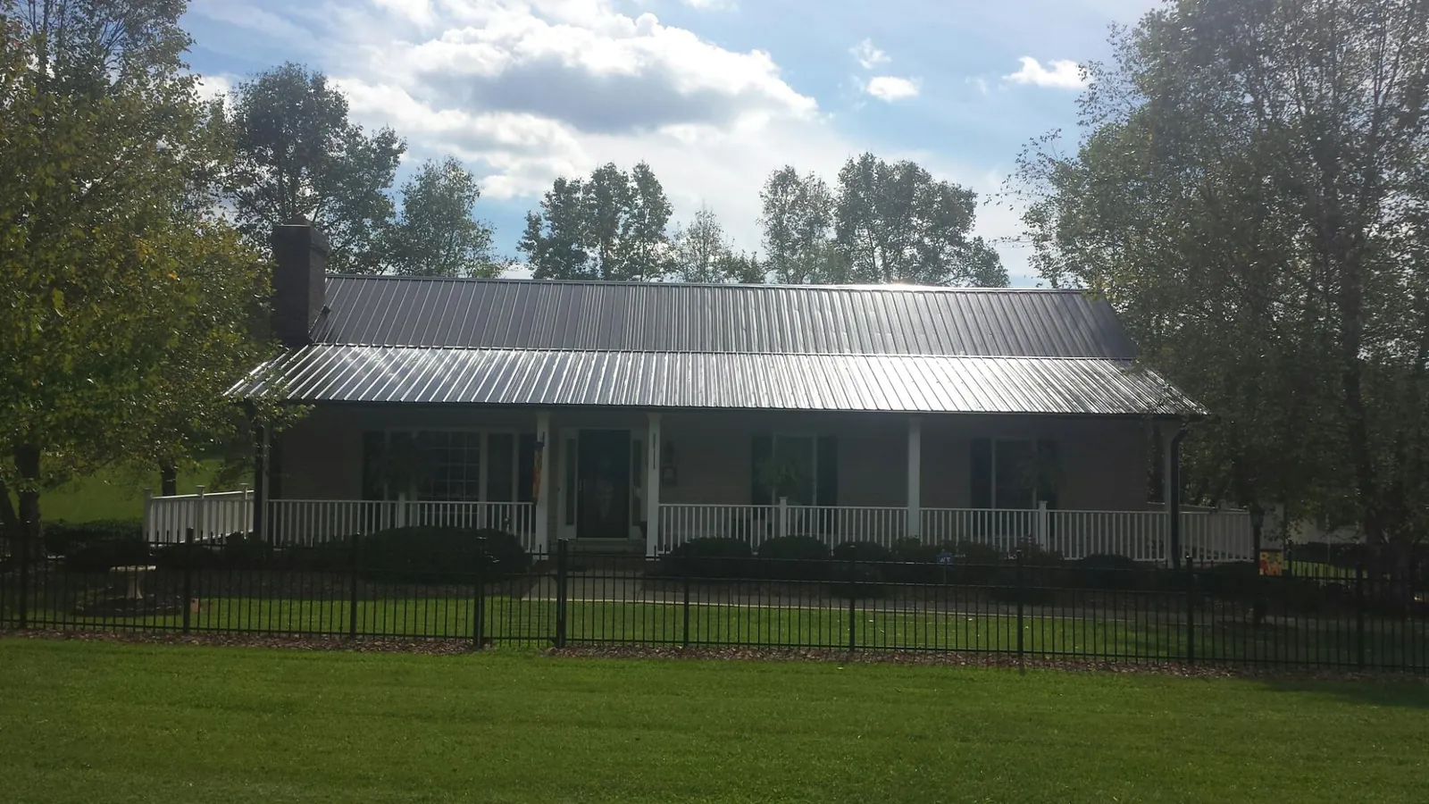 Gray metal roof on a brick ranch with a full width front porch — Gutter Guard Installation work by our crew in Donegal