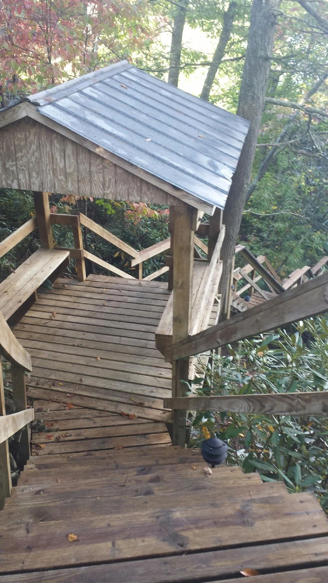 Metal roofed shelter over wooden steps on a wooded walkway — Skylight Repair & Installation work by our crew in Donegal