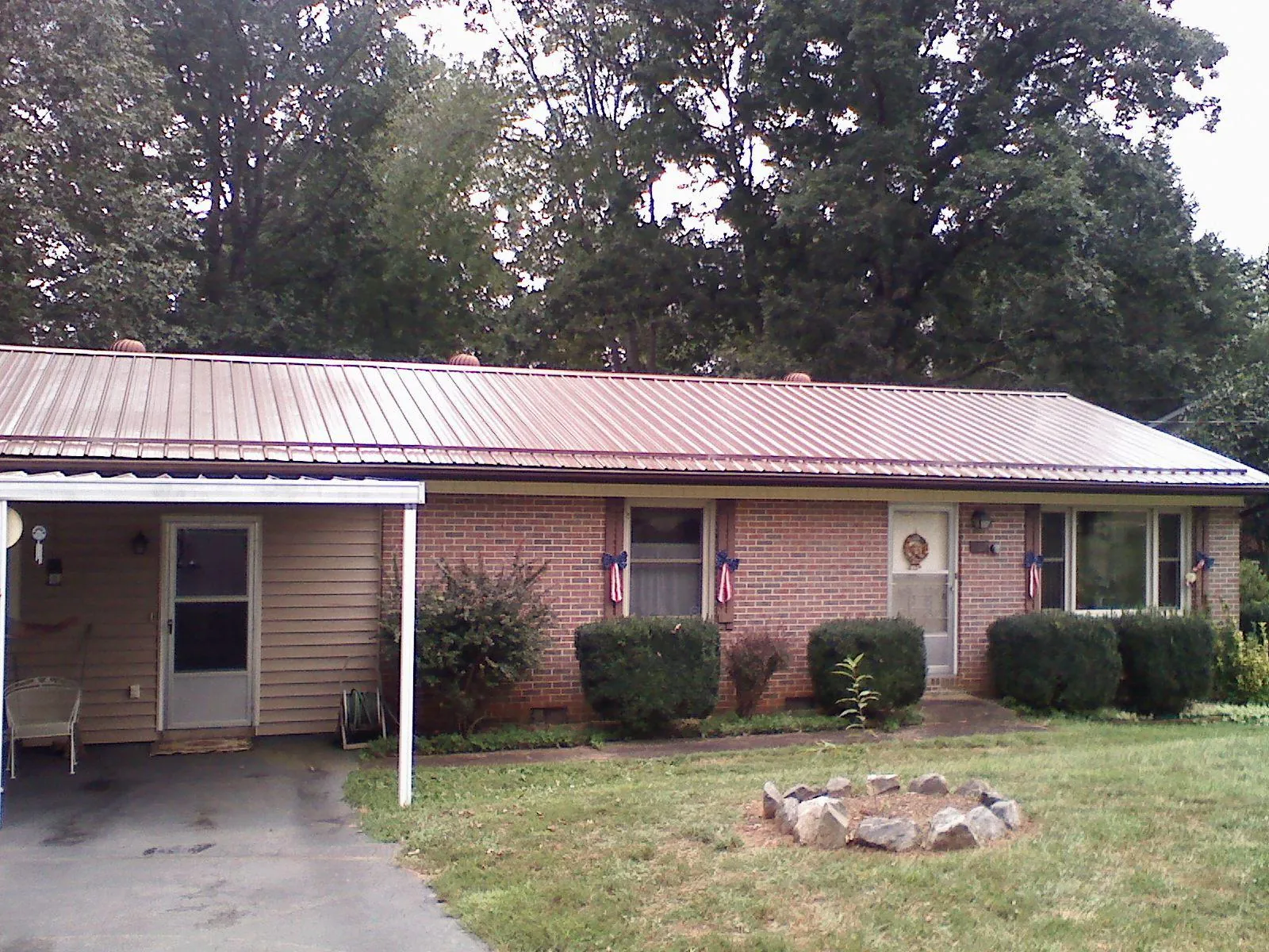 Bronze metal roof and carport on a brick ranch home — Roof Repair work by our crew in Donegal